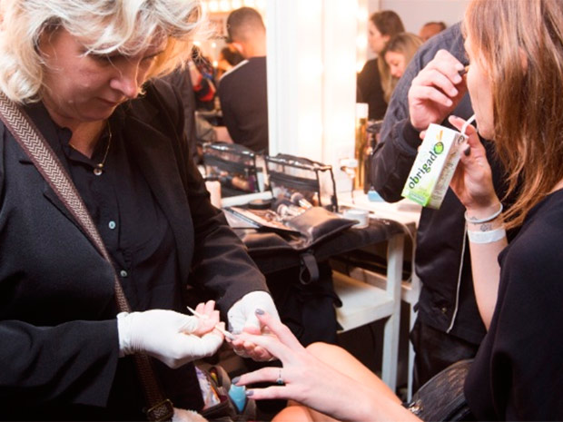 Manicure prepara as unhas de modelo para desfile na semana de moda de SP